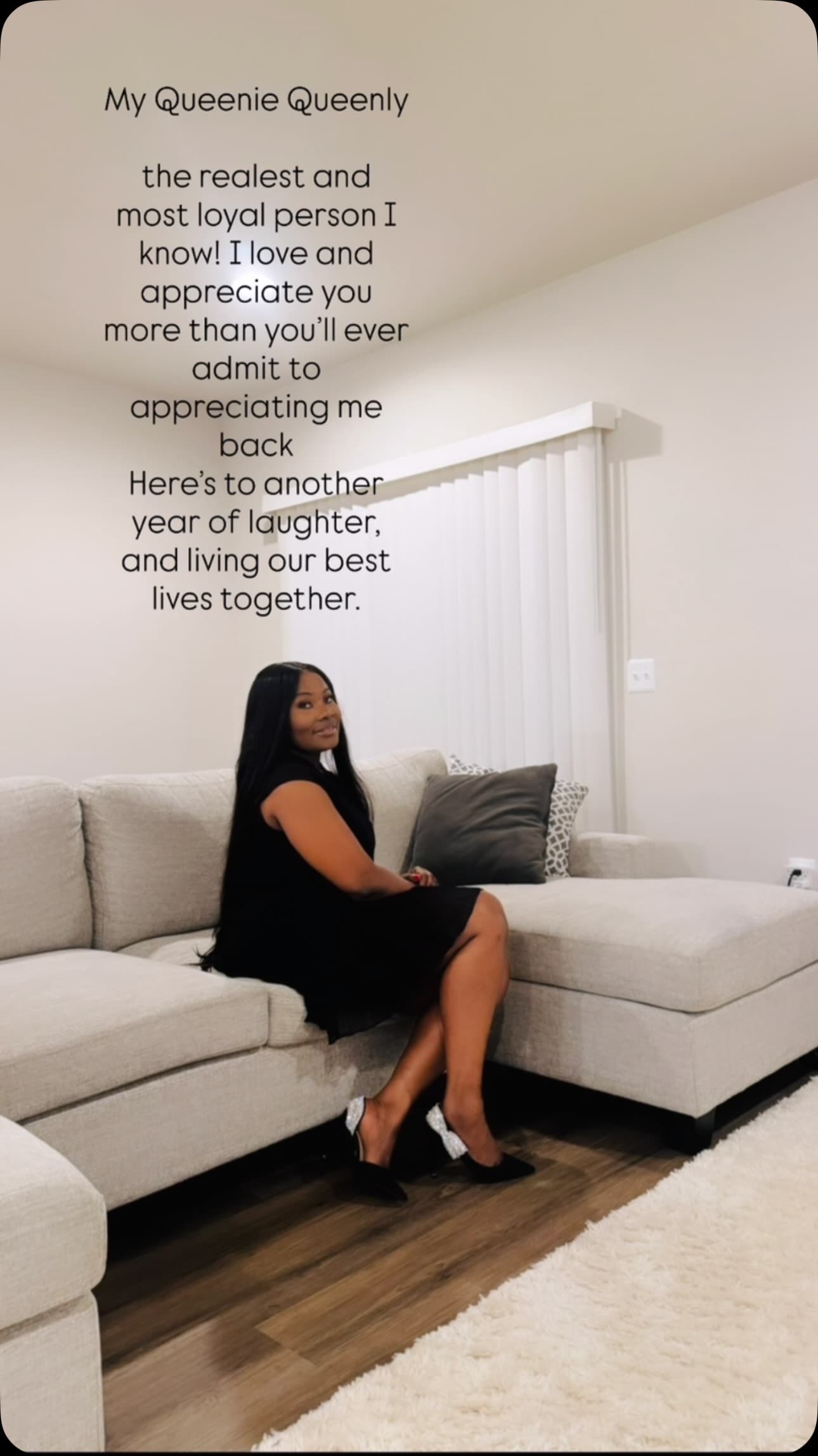 Malorfa in a black dress seated at home