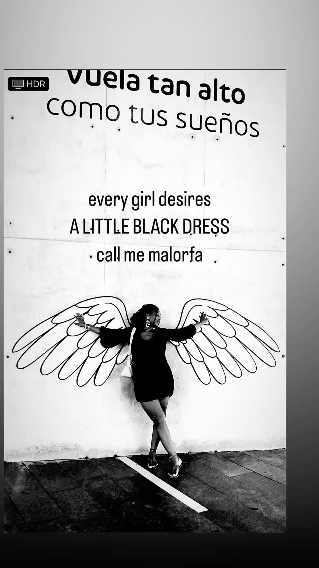 Black-and-white portrait of Malorfa with mural angel wings
